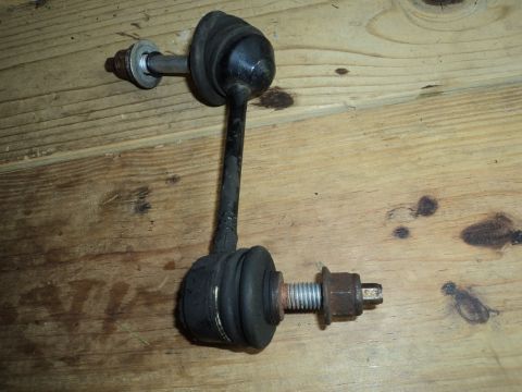 2004 Mercury Grand Marquis - A single sway bar end link is shown against a wooden background. The part has rubber bushings and metal fasteners.