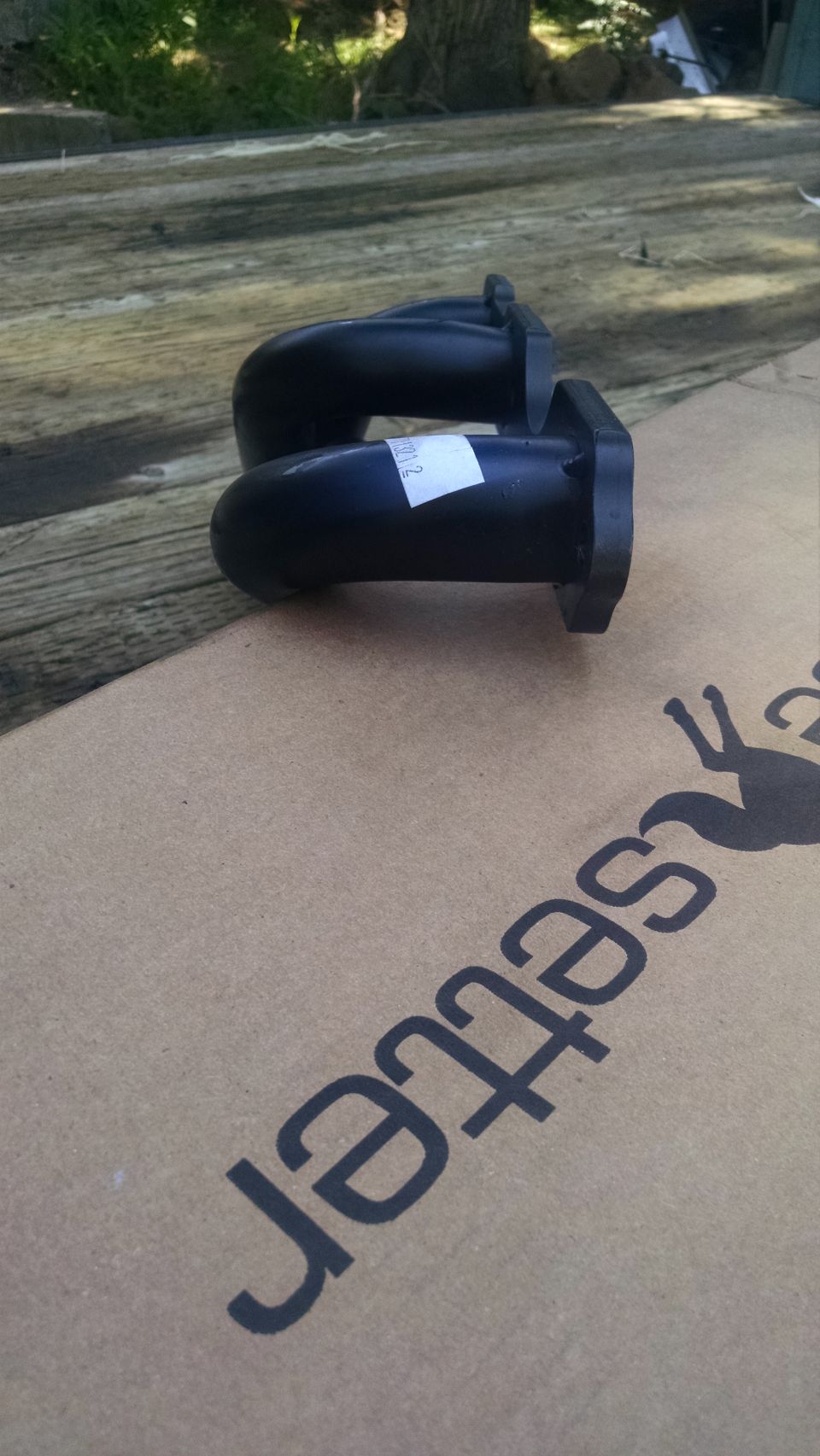 Pair of black exhaust tips with a white label