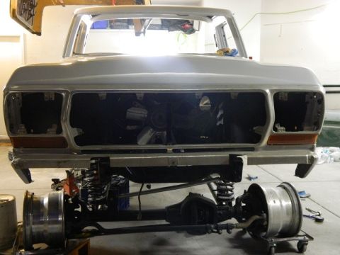 1979 Ford Bronco - Front view of a 1979 Ford Bronco undergoing restoration, showing the chassis and front clip with the axle detached.
