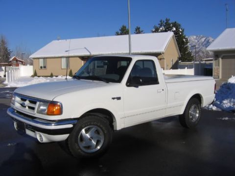 1979 Ford Bronco - A white Ford Ranger pickup truck is parked outside a snow-covered house on a clear day.