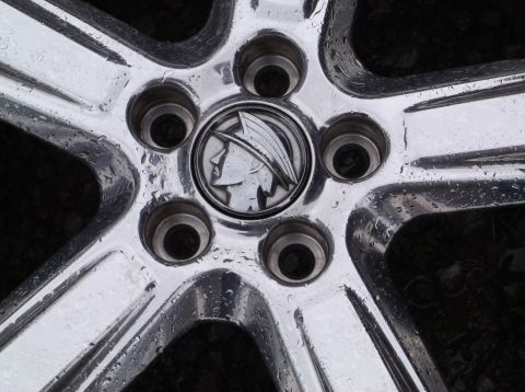 1999 Mercury Grand Marquis - Chrome wheel center cap the Mercury logo, covered in water droplets.