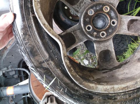 1999 Mercury Grand Marquis - A close-up view of a damaged wheel and tire, with the Supermotors.net logo visible at the bottom.