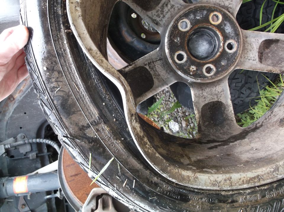 Damaged wheel and tire with Supermotors.net logo