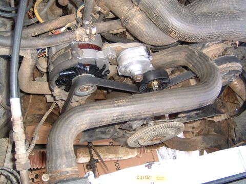 1987 Ford Bronco - Close-up of an engine bay, the alternator and drive belts. Visible text on the belt indicates 'McCORD AUTO PARTS'.