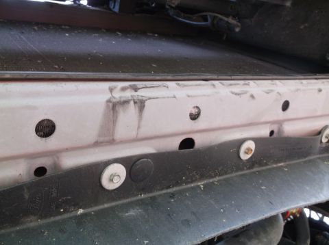 1999 Mercury Grand Marquis - This image shows a close-up view of a vehicle's radiator support structure, revealing some wear and tear.