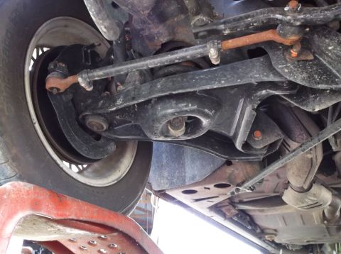 1999 Mercury Grand Marquis - Close-up view of the suspension system and wheel well from underneath a vehicle.