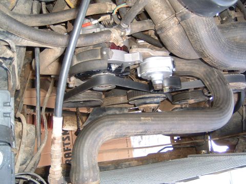 1987 Ford Bronco - Close-up view of an engine's water pump, serpentine belt, and pulleys. Some text is visible on the lower right.