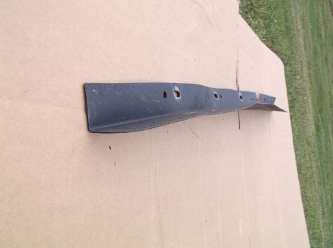1999 Mercury Grand Marquis - A black metal car part is shown on a piece of cardboard, with grass visible in the background.