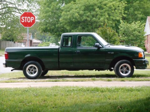 1997 Ford Ranger - This 1997 Ford Ranger pickup truck is shown from the side, parked on a grassy area next to a road.