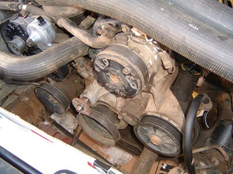 1987 Ford Bronco - Close-up view of an engine's water pump assembly, showing various pulleys and coolant hoses.