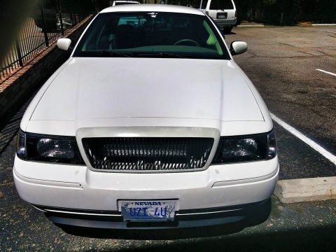 2000 Mercury Grand Marquis - Front view of a white 2000 Mercury Grand Marquis, a custom grille and aftermarket headlights.