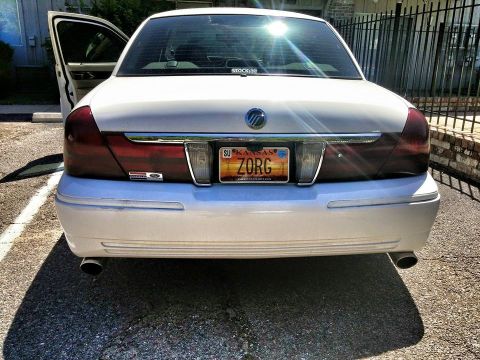 2000 Mercury Grand Marquis - Rear view of a white 2000 Mercury Grand Marquis showing the trunk, taillights, and license plate.