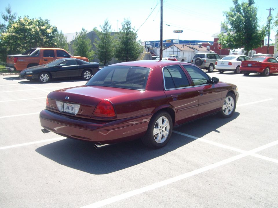Dark red Crown Victoria rear three-quarter view with dual exhaust and JUNIOR plate