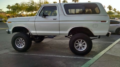 1979 Ford Bronco - This lifted 1978 Ford Bronco is parked in a lot with palm trees in the background.