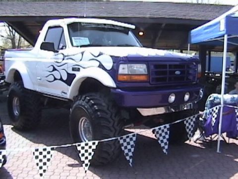 1995 Ford Bronco - This modified Ford Bronco features a two-tone paint job with flame graphics and oversized tires.