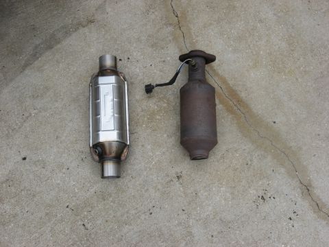 1994 Ford Bronco - Comparison of a new and old catalytic converter, both appear to be exhaust system parts.