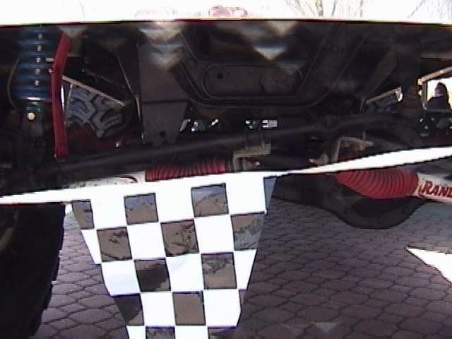 Undercarriage view of a vehicle with a checkered flag and visible suspension components