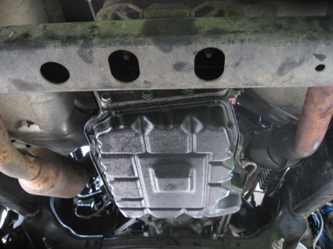 1994 Ford Bronco - Underside view showing the transmission pan and exhaust system components of a vehicle.