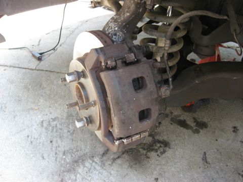 1994 Ford Bronco - Close-up view of a vehicle's brake caliper and rotor assembly.