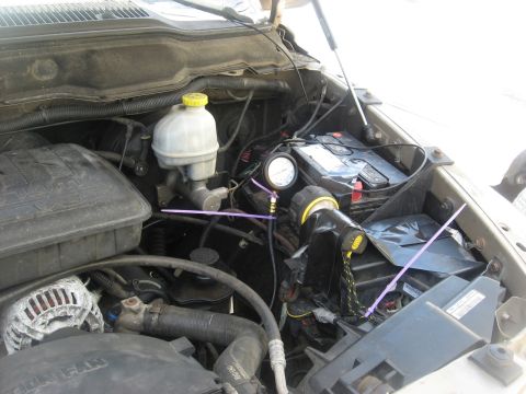 1994 Ford Bronco - Engine bay with a pressure gauge connected to the brake fluid reservoir for testing.