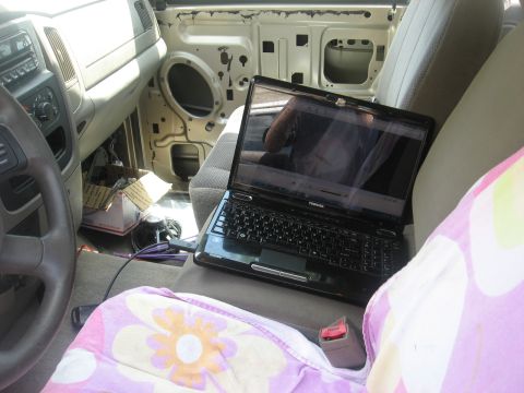 1994 Ford Bronco - Laptop on the center console inside a vehicle with the door panel removed.