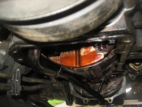 1994 Ford Bronco - Close-up view of an engine oil pan showing signs of an oil leak.