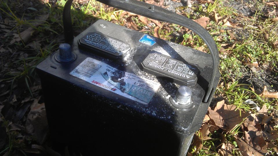 The battery hold down corroded and put excessive pressure on the battery case. I presume the cells shorted out as a result, though a properly functioning battery shouldn't offgas enough to corrode coated metal.