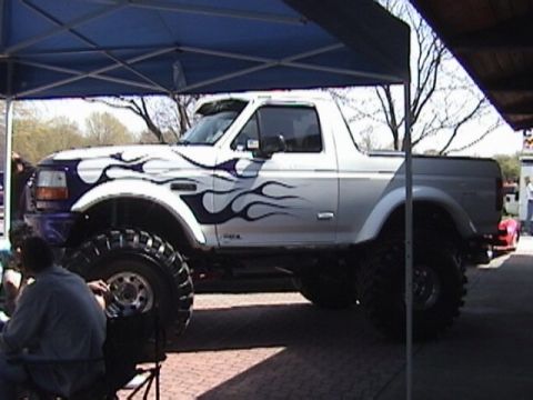 1995 Ford Bronco - This lifted 1995 Ford Bronco features custom flame decals and large off-road tires.