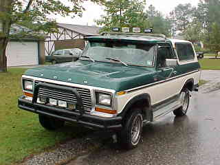 1995 Ford Bronco - Small front three-quarter snapshot of a green-over-white late-1970s Ford Bronco with FORD hood lettering, a black brush guard with driving…