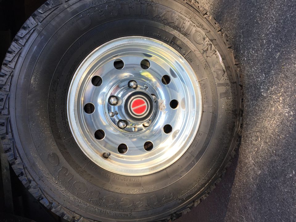 Chrome wheel with red Ford emblem and tire