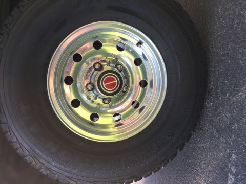 1994 Ford Bronco - Close-up of a vehicle's wheel and tire, showing the chrome rim and center cap.