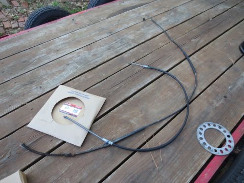 1994 Ford F-350 - Parking brake cables and a gasket are laid out on a wooden surface.