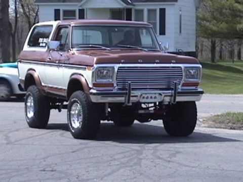 1995 Ford Bronco - This lifted Ford Bronco has a two-tone paint job and prominent chrome wheels.