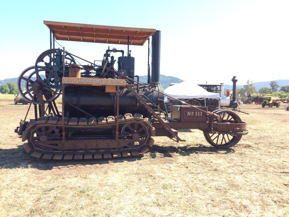 Vintage Holt Manufacturing Company crawler tractor labeled "No 111" with wooden canopy.