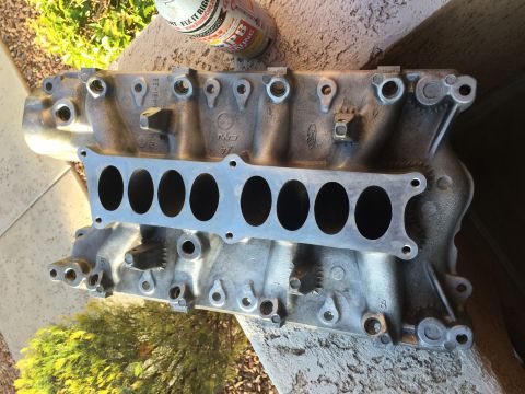 1996 Ford Bronco - A silver aluminum intake manifold with eight oval ports is shown mounted on a concrete surface. The manifold has the Ford logo and other ma…