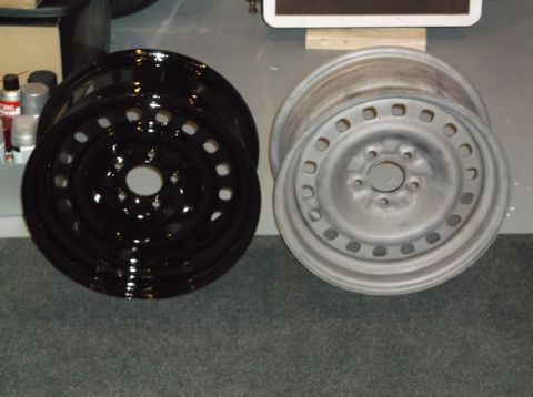 1999 Mercury Grand Marquis - Two car wheels are shown, one is black and glossy, and the other is a dull gray, possibly unpainted or primed.