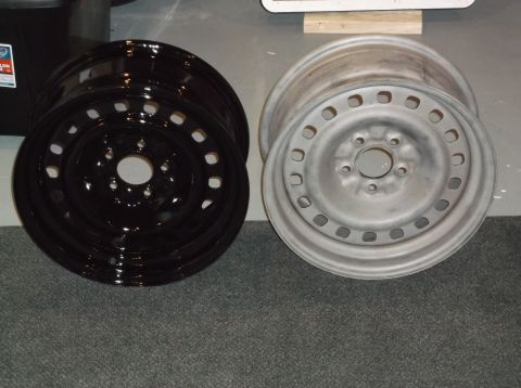 1999 Mercury Grand Marquis - Two steel wheels are shown. The wheel on the left is black and shiny. The wheel on the right is a dull silver color.
