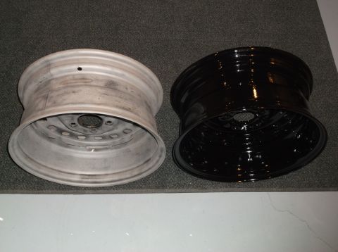 1999 Mercury Grand Marquis - Two car rims are shown side-by-side on a carpeted surface. The rim on the left is unpainted and appears weathered, while the rim on the rig…