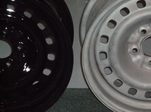 1999 Mercury Grand Marquis - A close-up, side-by-side view of two car wheels. The wheel on the left is black and glossy, while the wheel on the right is a matte silver…