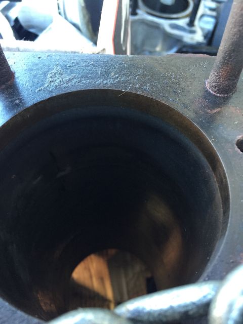 1946 Jeep Willys - A close-up view of the inside of a cylinder bore, showing some dust and residue on the top edge. The interior of the cylinder appears dark…