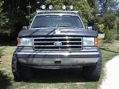 1995 Ford Bronco - This 1995 Ford Bronco features a front-facing view, complete with a roof rack and auxiliary lighting for off-road adventures.