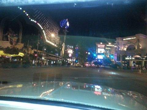 1979 Ford Bronco - Nighttime view of the Las Vegas Strip, showing illuminated buildings and streetlights, as seen from a car.