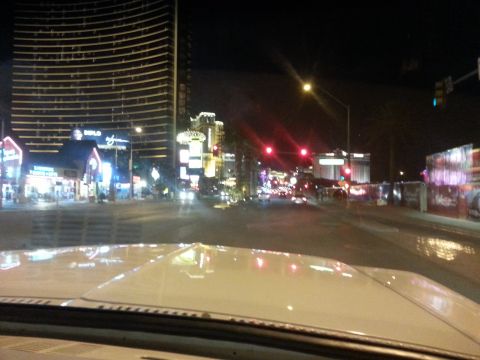 1979 Ford Bronco - Driving through a brightly lit city at night, with tall buildings and traffic lights visible.