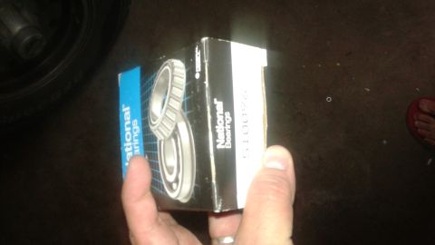 2008 Mazda 3 - A box of National Bearings is held in a hand, with a tire visible in the background.