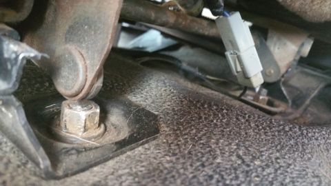 1995 Ford F-150 - Seat mounting bolt and wiring connector visible in the interior of a vehicle.