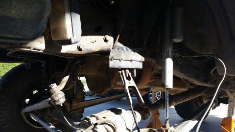 1991 Ford Bronco - Close-up view of vehicle undercarriage modifications, showing suspension parts and welding work.