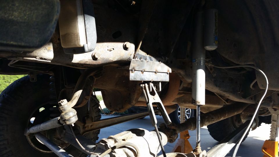 Undercarriage of a vehicle with suspension components and a metal bracket being welded