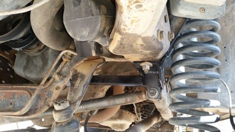 1991 Ford Bronco - Close-up of the vehicle's undercarriage, focusing on the suspension system and a newly installed bracket.