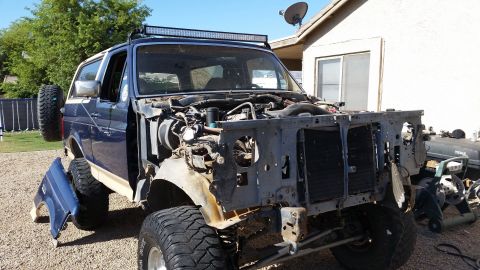 1991 Ford Bronco - This Ford Bronco is missing its front grille and bumper, revealing the engine bay and radiator.