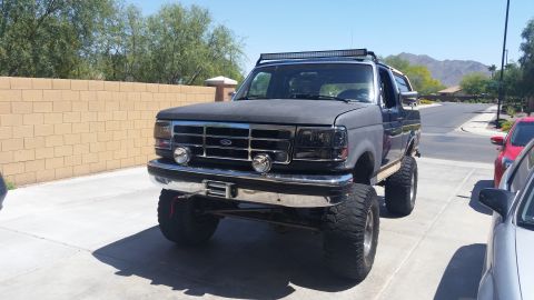 1991 Ford Bronco - This lifted Ford Bronco has a custom grille, headlights, and an LED light bar mounted on the roof.